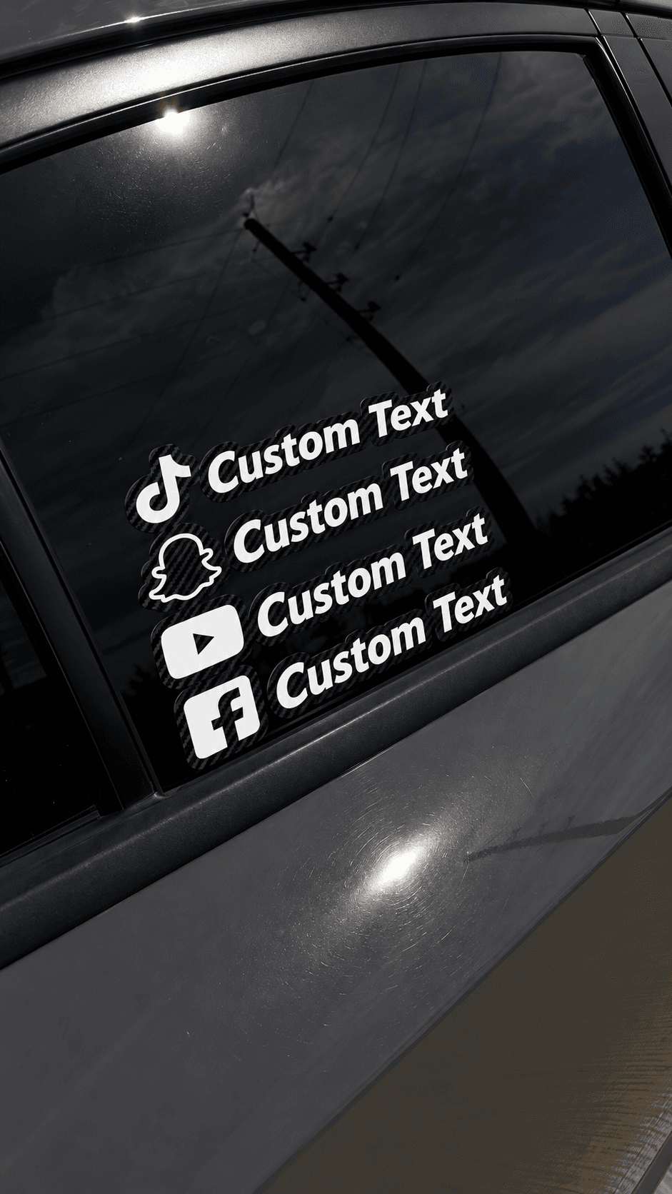 Four custom social media handle decals with a carbon-fiber backing on a car's rear window